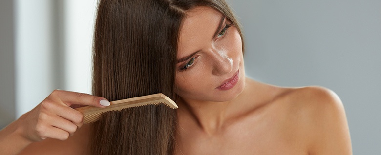 kobieta podczas czesania włosów brunetka
